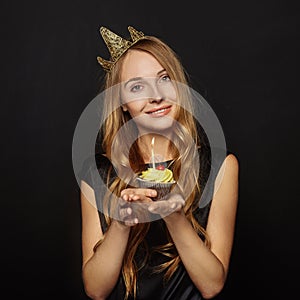 Attractive girl with a crown and cupcake