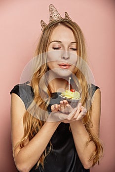 Attractive girl with a crown and cupcake