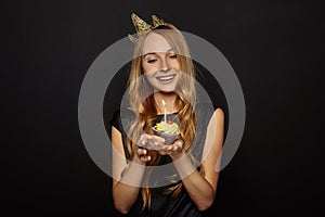 Attractive girl with a crown and cupcake