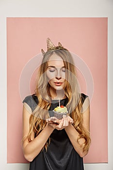 Attractive girl with a crown and cupcake