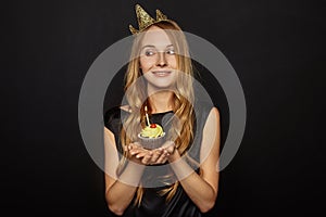 Attractive girl with a crown and cupcake