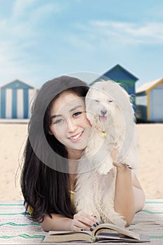 Attractive girl with dog and book at shore