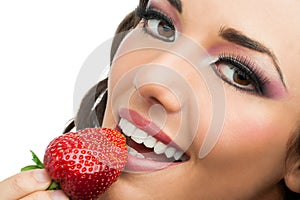 Attractive girl eating strawberry.
