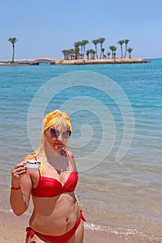 Girl enjoying relax drinking coffee on beach. Woman relaxing standing in sea