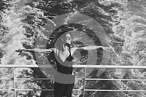 Attractive girl feels free and enjoy summer vacation. Freedom concept. lady stands on deck of cruise liner with sea