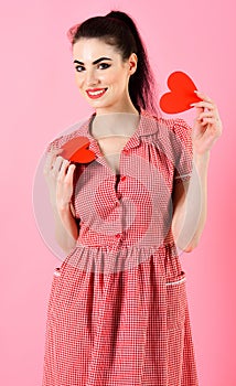 Attractive girl holding two red hearts