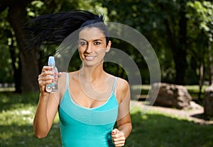 Attractive girl jogging in nature smiling