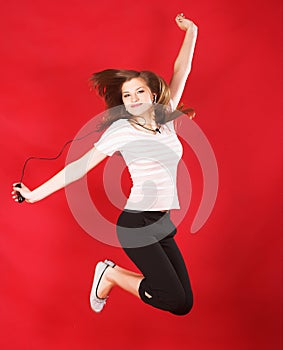 Attractive girl jumping of joy over red