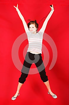 Attractive girl jumping of joy over red