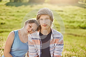 Attractive girl leaning at shoulder of her boyfriend closing her eyes with pleasure enjoyong together calm atmosphere while sittin