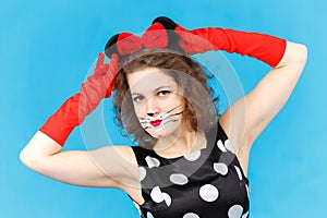 Attractive girl in likeness of cat on blue background posing