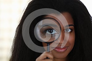 Attractive girl looking through magnifier, smiling