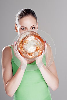 Attractive girl looks out behind a round bun.