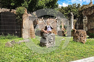 Attractive girl near the picturesque ruins of Rome, Italy