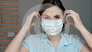 Attractive girl puts on surgical mask on her face. Cold, flu, virus, acute respiratory infections, quarantine, epidemic, irony, photo