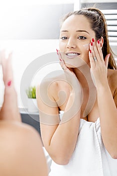 Attractive girl putting anti-aging cream