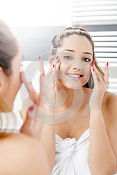 Attractive girl putting anti-aging cream