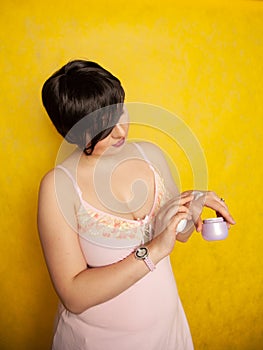 Attractive girl putting anti-aging cream on her palm arm