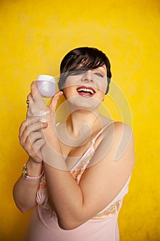 Attractive girl putting anti-aging cream on her palm arm