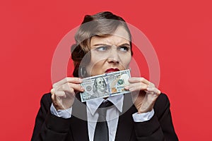 Attractive girl in retro style holds a 100 dollar bill in front of her nose