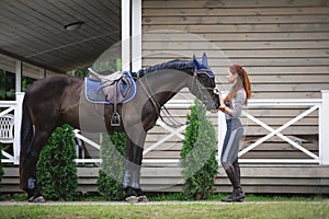 Attractive girl rider and black hanoverian stallion