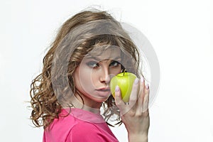 Attractive girl seductively holds a ripe green apple in her hands