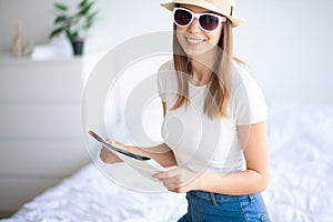 Attractive girl sitting on sofa and packing luggage