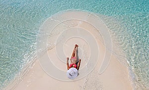 Attractive girl tanning on a sandbank in the Maldives