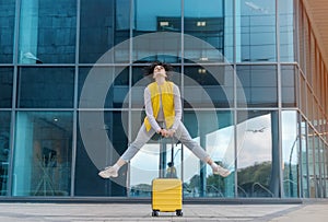 attractive glad woman jumping holding suitcase. woman enjoys vacation Passenger travel abroad on weekends getaway Air flight