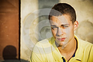 Attractive green eyed young man leaning against wall outside