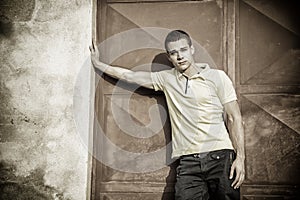 Attractive green eyed young man leaning against wall outside