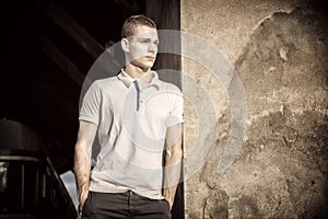 Attractive green eyed young man leaning against wall outside