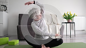 Attractive Grey-Haired Senior Woman Practicing Fitness Training And Side Bend Stretching At Home