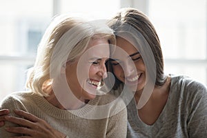 Attractive grown up daughter and middle aged mother laughing photo