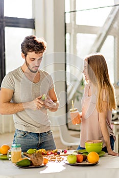 Attractive guy is haring apple with agirl in the kitchen