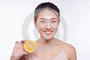 Attractive half-naked asian woman amiling while holding orange slices near her face