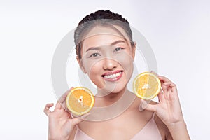 Attractive half-naked asian woman amiling while holding orange slices near her face