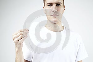 Attractive handsome businessman holding, showing empty business card, space for layout, with white background