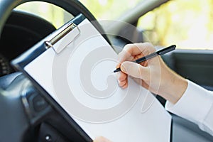 Attractive handsome elegant man in a business suit driving an expensive car.