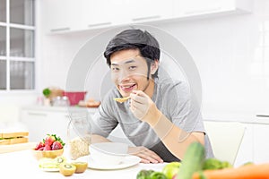 Attractive handsome man eat breakfast or cereal, fruits, milk on photo