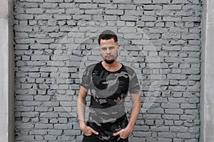 Attractive handsome young man in a fashion camouflage t-shirt