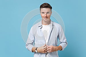 Attractive handsome young man guy 20s in casual shirt posing isolated on pastel blue wall background studio portrait
