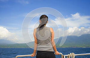 Attractive and happy Asian Chinese woman on excursion ship or ferry looking ocean and island enjoying sea breeze on summer holiday