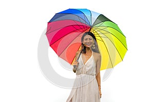 Attractive and happy Asian woman holding rainbow colorful umbrella or parasol  smiling playful isolated on white background in