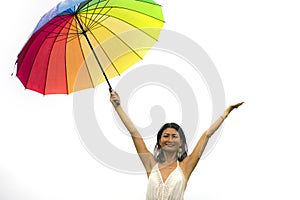 Attractive and happy Asian woman holding rainbow colorful umbrella or parasol  smiling playful isolated on white background in