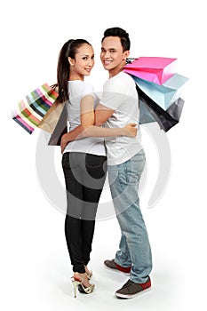 Attractive happy couple carrying shopping bag