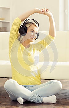 Attractive happy girl listening music at home.