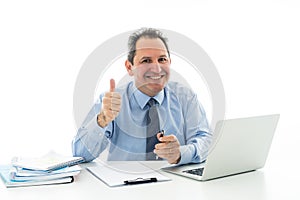 Attractive happy mature caucasian businessman working on laptop computer feeling successful at work