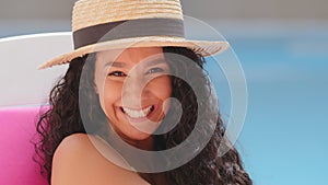 Attractive happy millennial Hispanic girl in summer hat enjoying vacation. Closeup headshot young woman smiling