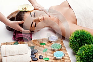 Attractive Happy relaxing girl at beauty spa treatment. Beauty young woman recieving head massage at spa, massager